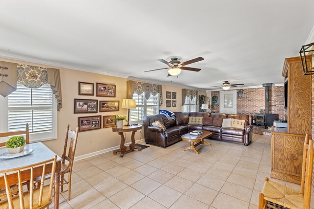 living area with light tile patterned floors, crown molding, a wood stove, and baseboards