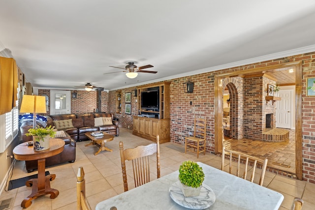 dining space with tile patterned floors, brick wall, and a wood stove