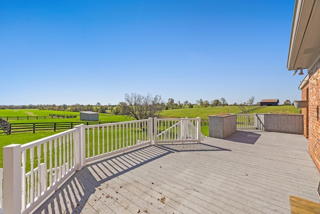 deck with a rural view and a yard