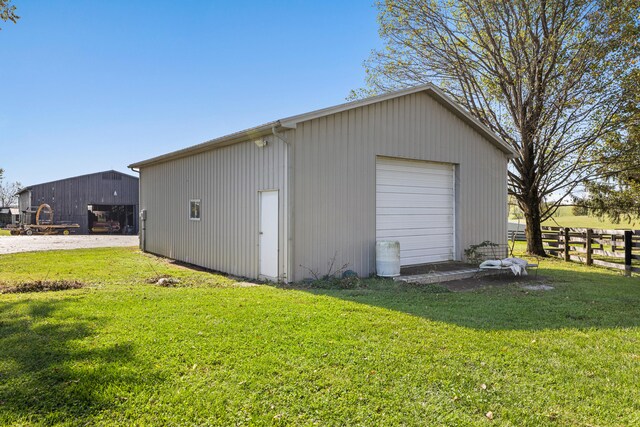 detached garage featuring fence and driveway