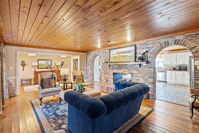 living area featuring arched walkways, a fireplace, and brick wall