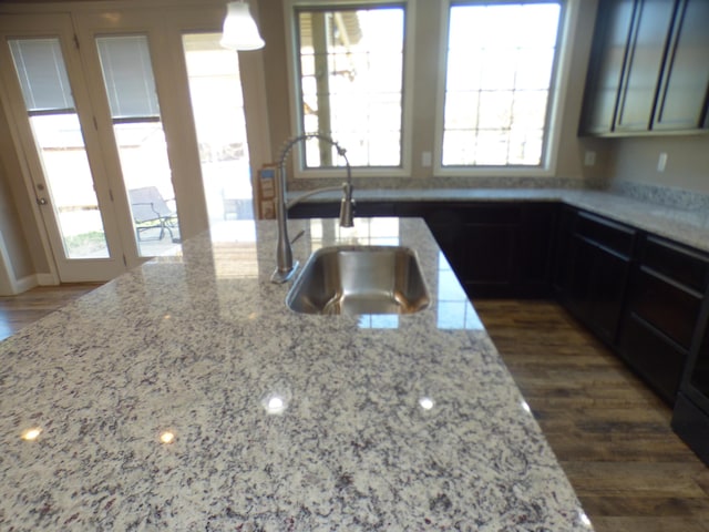 kitchen with light stone counters, plenty of natural light, and a sink