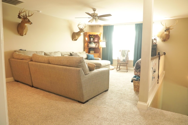 carpeted living area with visible vents, baseboards, and a ceiling fan