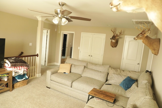 living area with baseboards, a ceiling fan, and carpet