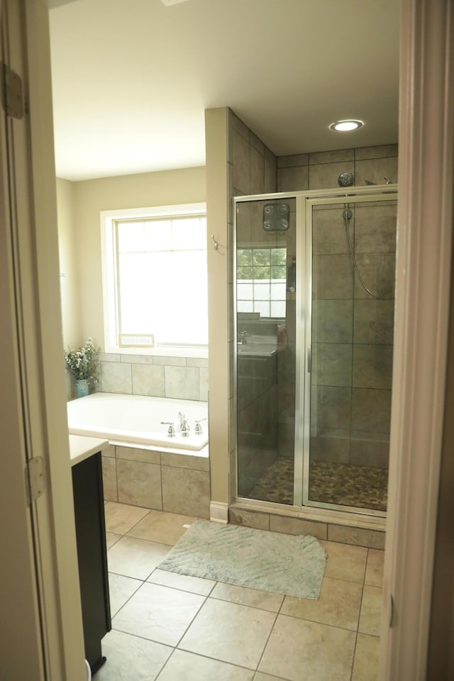 bathroom with tile patterned floors, a garden tub, and a shower stall