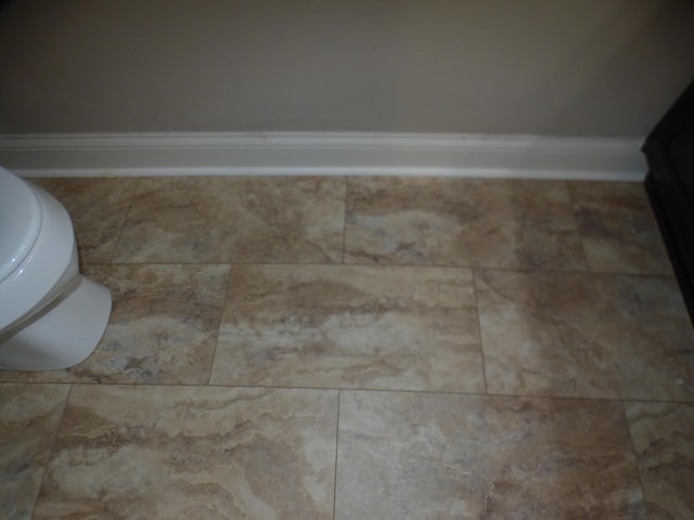 interior space with toilet and baseboards