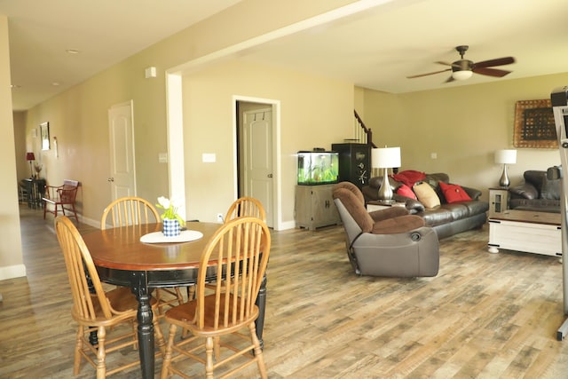 dining area with light wood finished floors, baseboards, and a ceiling fan