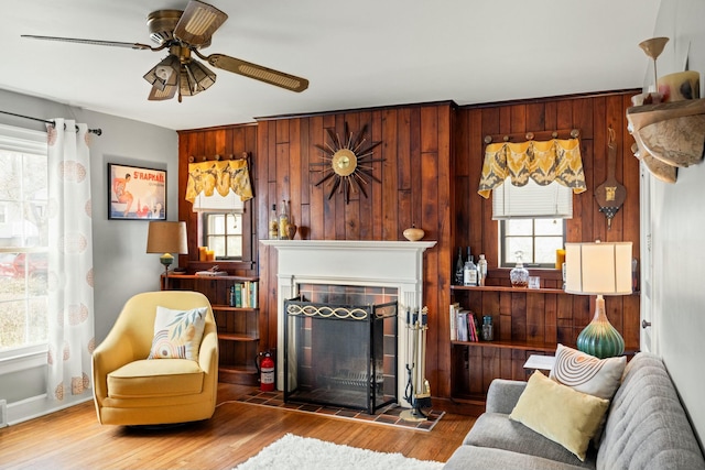 living room featuring wood finished floors, a fireplace, and wood walls