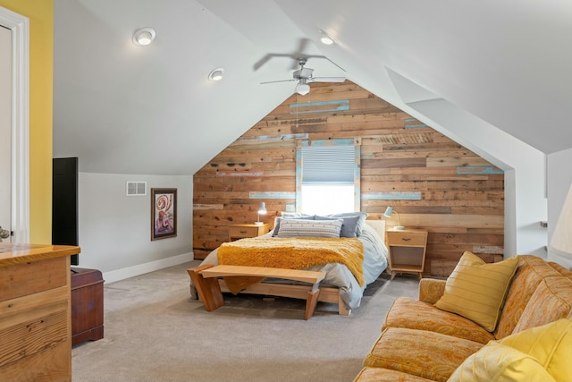 bedroom with visible vents, wood walls, carpet, and vaulted ceiling