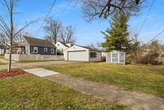 view of yard with an outbuilding, a detached garage, and a fenced front yard