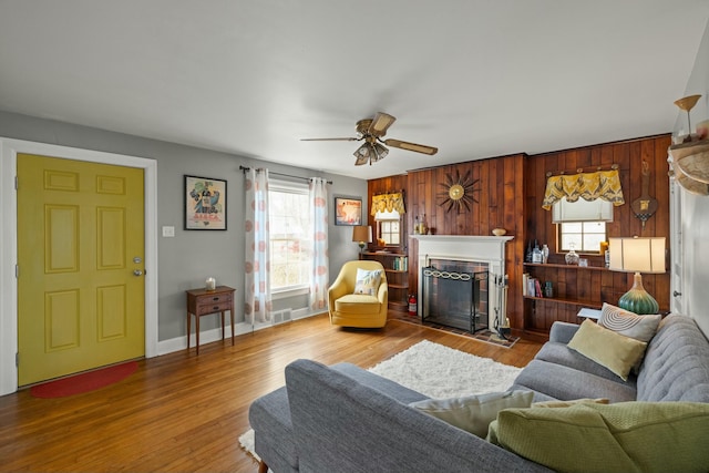 living room featuring visible vents, baseboards, wood finished floors, and a fireplace