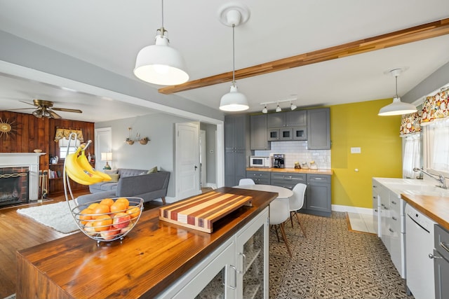 dining room featuring a fireplace, beam ceiling, a healthy amount of sunlight, and baseboards