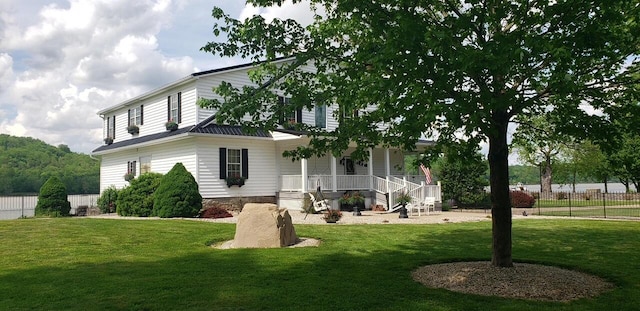 exterior space featuring a lawn, a porch, and fence