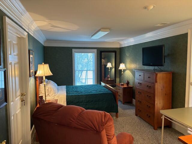 carpeted bedroom featuring crown molding