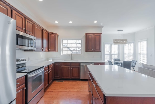 kitchen with crown molding, light countertops, plenty of natural light, stainless steel appliances, and a sink