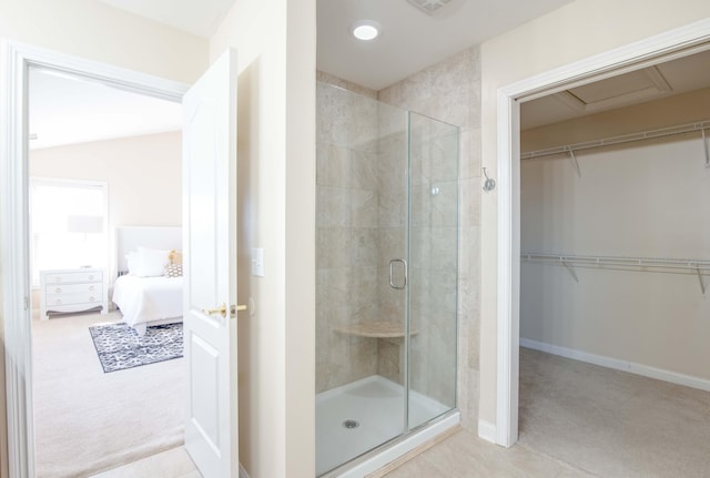 full bathroom with a spacious closet, baseboards, a stall shower, and connected bathroom