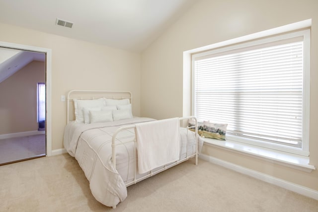 bedroom featuring visible vents, light carpet, multiple windows, and vaulted ceiling