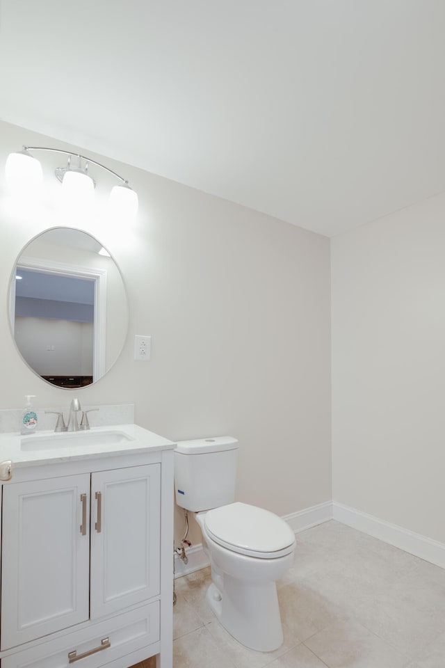 bathroom with tile patterned flooring, toilet, vanity, and baseboards