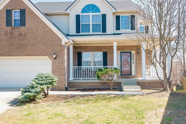 traditional home with covered porch, brick siding, and a shingled roof