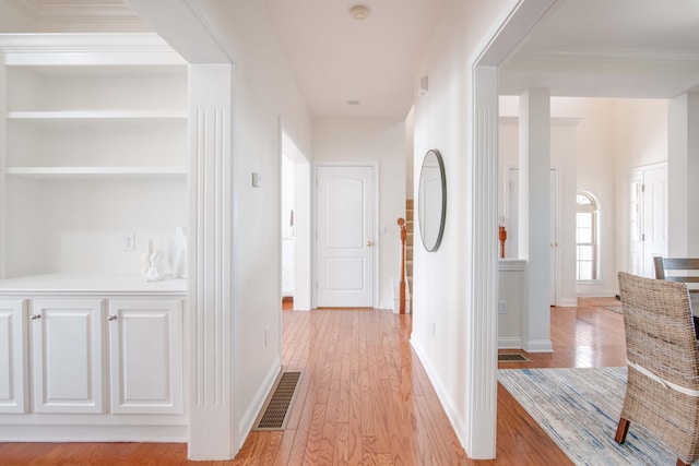 hall with baseboards, visible vents, and light wood-type flooring