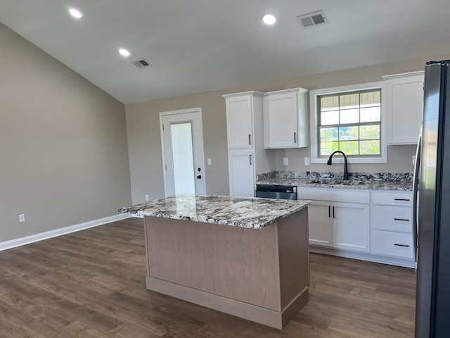 kitchen featuring a sink, stainless steel appliances, white cabinetry, visible vents, and a kitchen island