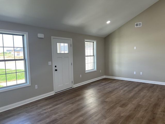 entryway featuring lofted ceiling, dark wood-style flooring, visible vents, and a healthy amount of sunlight