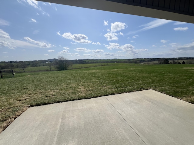 view of yard with a rural view and a patio