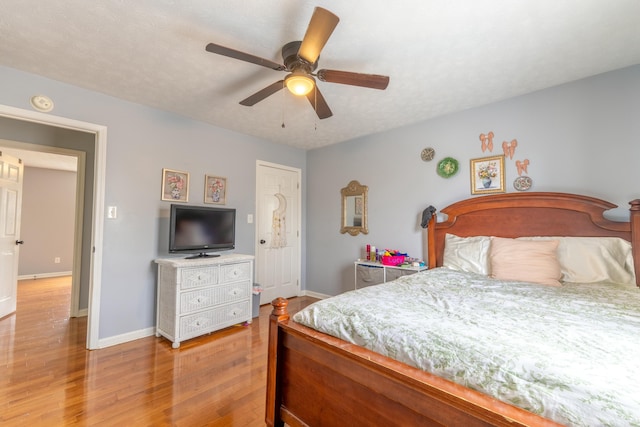 bedroom featuring wood finished floors, baseboards, and ceiling fan