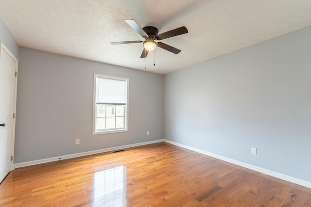 spare room with visible vents, baseboards, a textured ceiling, and light wood-style flooring