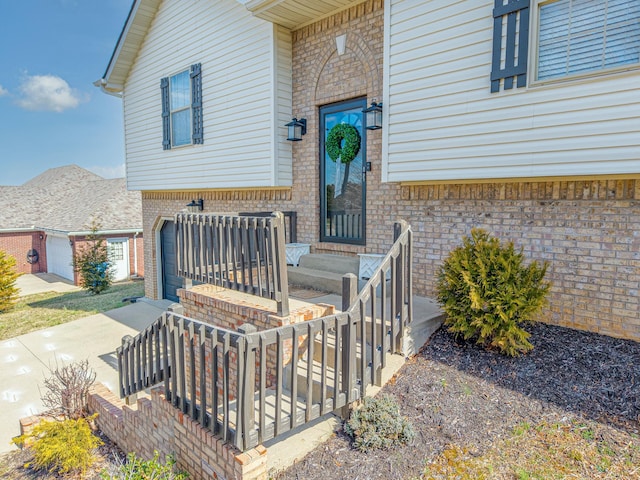 entrance to property with brick siding and a garage