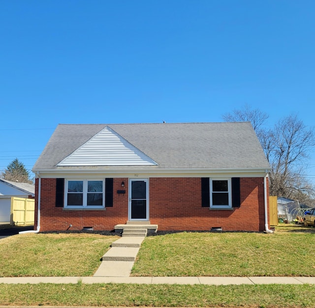 view of front of home with brick siding, entry steps, and a front yard