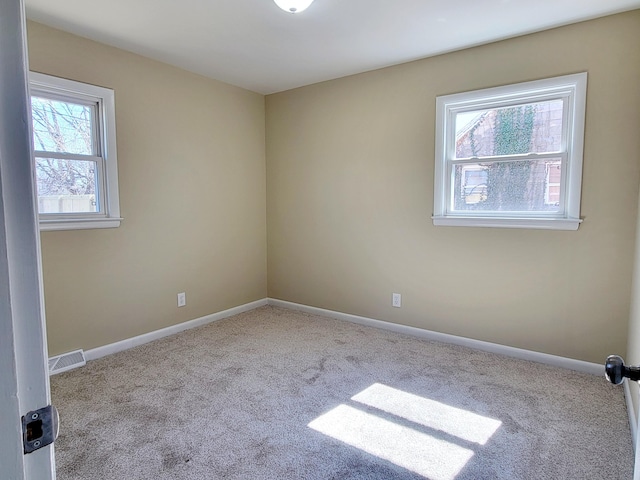 unfurnished room with visible vents, baseboards, and carpet