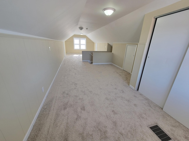 additional living space featuring visible vents, carpet flooring, and vaulted ceiling