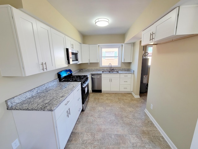 kitchen with a sink, baseboards, white cabinetry, and stainless steel appliances