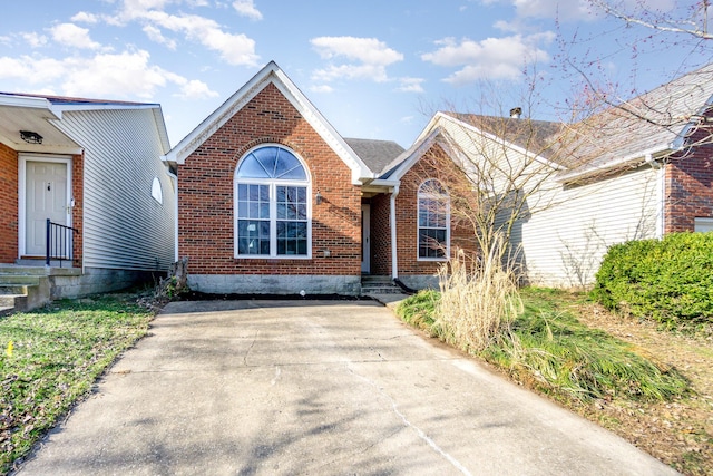 view of front of home featuring concrete driveway and brick siding