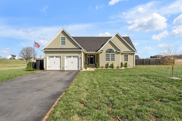 view of front of property with aphalt driveway, fence, and a front yard