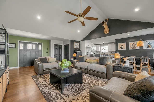 living room featuring high vaulted ceiling, wood finished floors, a wealth of natural light, and ceiling fan