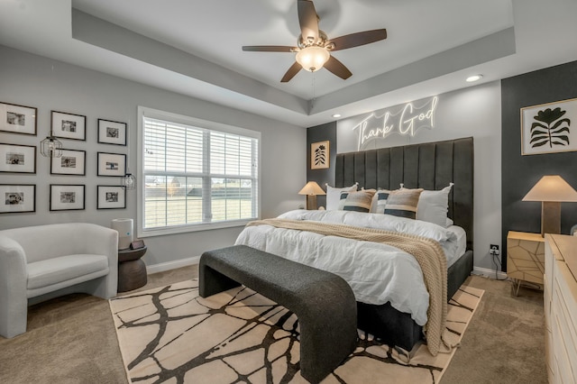 bedroom with a tray ceiling and carpet floors