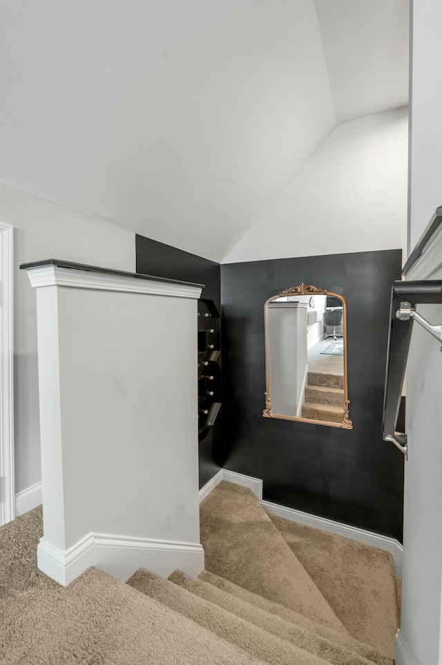 stairs with carpet flooring, baseboards, and vaulted ceiling