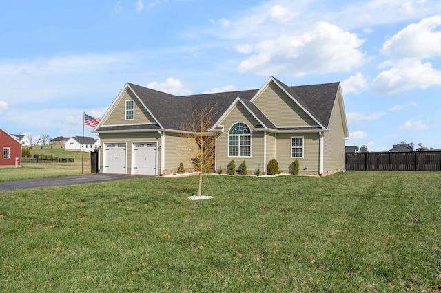 view of front facade featuring aphalt driveway, an attached garage, a front lawn, and fence