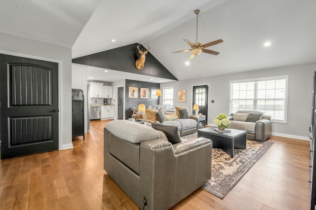 living room with high vaulted ceiling, baseboards, light wood-style floors, and ceiling fan