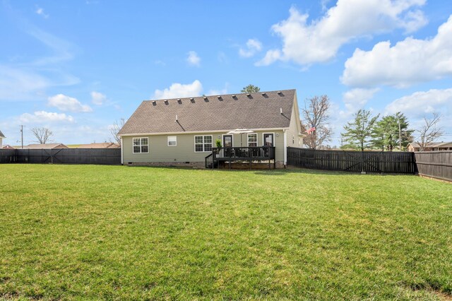 rear view of property with crawl space, a wooden deck, a fenced backyard, and a lawn