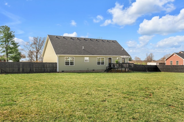 back of property with a fenced backyard, a yard, a wooden deck, a shingled roof, and crawl space