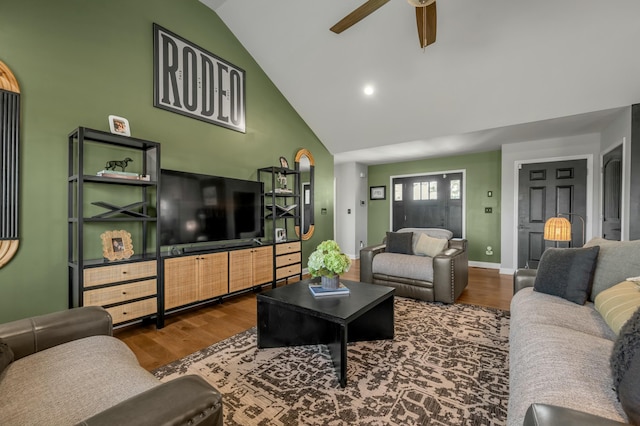 living room featuring high vaulted ceiling, baseboards, ceiling fan, and wood finished floors