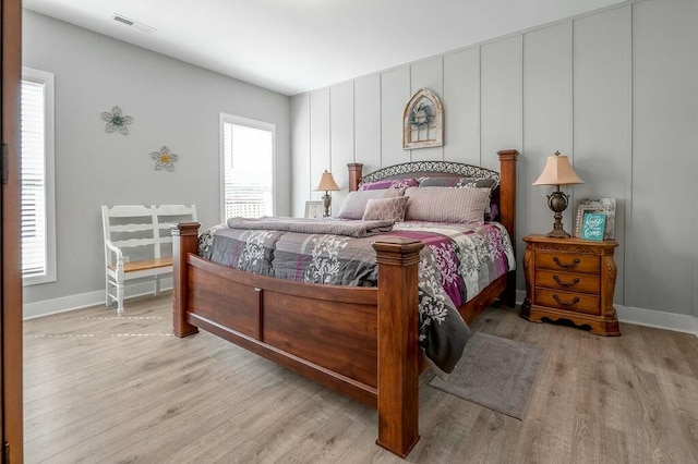 bedroom with visible vents, baseboards, and wood finished floors