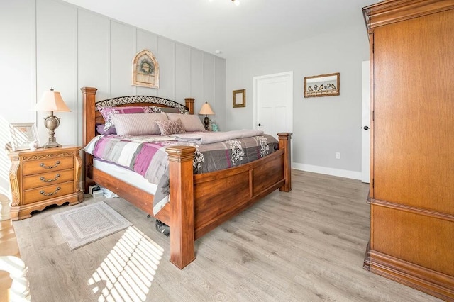 bedroom featuring baseboards and light wood finished floors