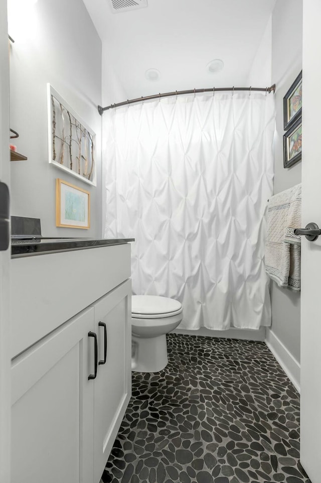 bathroom featuring vanity, toilet, and shower / tub combo with curtain