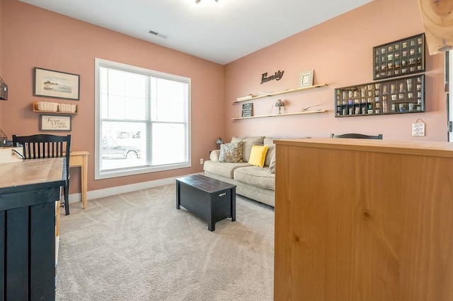 living room featuring visible vents, wet bar, baseboards, and carpet flooring