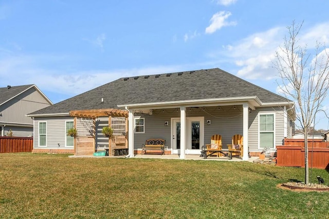 back of house featuring a shingled roof, fence, a yard, a pergola, and a patio