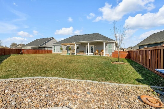 back of property with a yard, a patio area, and a fenced backyard